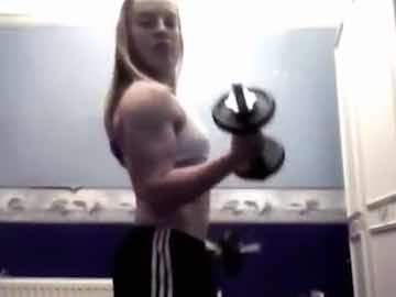 Young Blonde Girl With Muscles Doing Exercises With Dumbbells